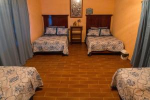 une chambre avec trois lits dans une pièce dans l'établissement Casa Vacacional en calvillo, à El Rodeo