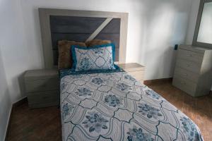 une chambre avec un lit avec une couette bleue et blanche dans l'établissement Casa Vacacional en calvillo, à El Rodeo