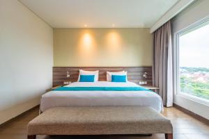 Postel nebo postele na pokoji v ubytování Hotel AYOLA Lippo Cikarang + 25 fotografií