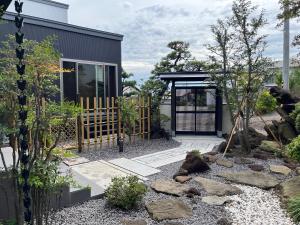 a garden with a black house and a gate at Akashi in Hakodate