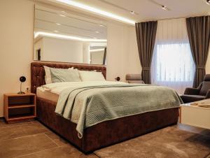 een slaapkamer met een groot bed en een spiegel bij Hotel Europa 92 in Ferizaj