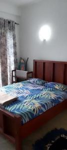 a bedroom with a bed with a blue comforter at Stag Mountain Resort in Ettampitiya
