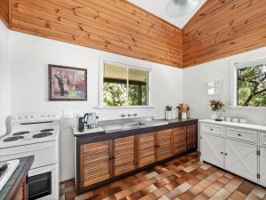 una cucina con elettrodomestici bianchi e soffitto in legno di Ryma Cottage - Prevelly NEW a Prevelly Altre 9 foto
