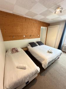 a room with two beds in a room at Hotel de Trois St Gervais in Saint-Gervais-les-Bains