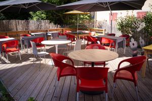a deck with tables and chairs and umbrellas at Hotel de Trois St Gervais in Saint-Gervais-les-Bains +9 photos