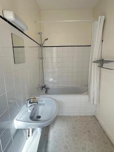 a bathroom with a sink and a bath tub at Hotel de Trois St Gervais in Saint-Gervais-les-Bains