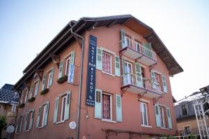 a pink building with a sign on the side of it at Hotel de Trois St Gervais in Saint-Gervais-les-Bains