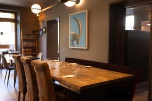 a dining room with a wooden table and chairs at Hotel de Trois St Gervais in Saint-Gervais-les-Bains