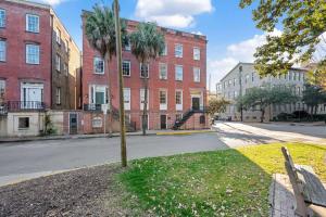 a tree in the middle of a street with buildings at No Car Needed King Bed Balcony Abercorn And York-2 in Savannah