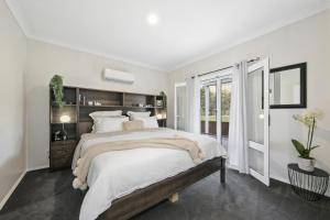 Un dormitorio blanco con una cama grande y una ventana. en Little Corner Farm, en Broke