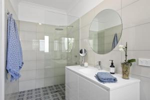Un baño blanco con lavabo y espejo. en Little Corner Farm, en Broke 27 fotos más