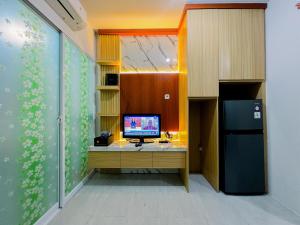 a room with a desk with a computer on it at Compact and Relaxing 2BR at Suncity Residence Apartment By Travelio in Sidoarjo