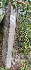 a stone with the on it next to a fence at Chambre climatisée in Bouillante +5 photos
