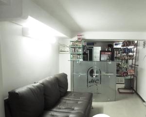 a living room with a leather couch and a refrigerator at Hotel del Comercio in Villavicencio