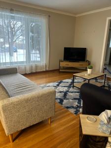 a living room with a couch and a tv at Cheerful 4 bedroom with sunroom in Belleville