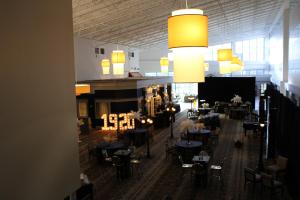 a restaurant with people sitting at tables in a room at Wyndham Flint MI Grand Blanc Bishop Airport Conference Ct in Flint