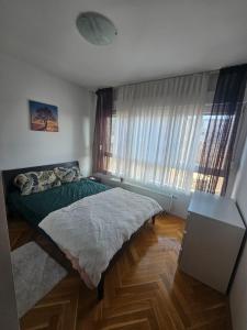una camera da letto con un letto, un tavolo e una finestra di Cozy Room Near The Center a Zagabria