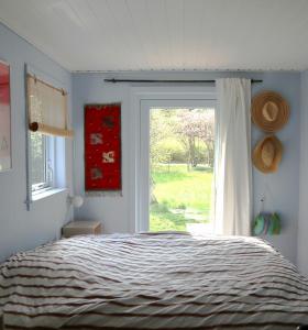 - une chambre avec un lit à côté d'une fenêtre dans l'établissement Summer House Charm Near Hårbølle Havn, à Askeby