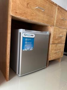 um pequeno frigorífico debaixo de uma secretária numa cozinha em GJE's LODGE AND GUEST HOUSE em Moalboal