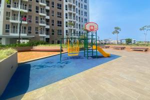 a playground with a slide and a basketball hoop at Good and Cozy Stay 2BR Tokyo Riverside PIK 2 Apartment By Travelio in Tangerang