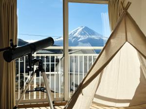 浅川にある81 Guest House -ANKI-の望遠鏡付きの部屋から雪に覆われた山の景色を望めます。