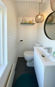 Un baño blanco con inodoro y lavabo. en Home In Horne Sommerland With Sea View, en Faaborg
