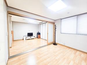 an empty living room with a large window and a television at Damyang Mulgusimni Group Pension in Damyang