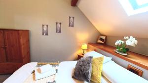 多尔盖罗Cader Mountain View Cottage with Hot Tub in Snowdonia的卧室配有白色的床,墙上挂着一些图片