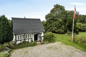 a white house with a flag in front of it at Timber-Framed With Bright And Idyllic Garden in Juelsminde