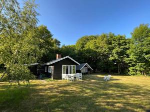 a small house with a picnic table in a yard at Cosy Cabin Collection In Veddinge Bakker in Asnæs