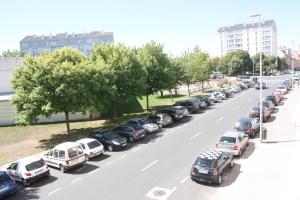 uma longa fila de carros estacionados numa rua da cidade em Residencia Porta Nova em Ferrol