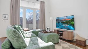 a living room with a couch and a tv at Chic Modern Condo in the Vibrant NuLu District in Louisville