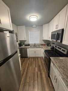 a kitchen with white cabinets and a stainless steel refrigerator at Perkins Cove in Baton Rouge