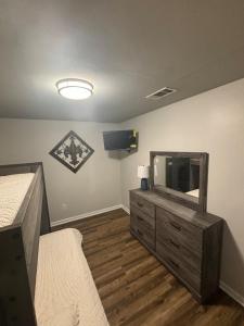 a bedroom with a tv and a dresser with a mirror at Perkins Cove in Baton Rouge +4 photos