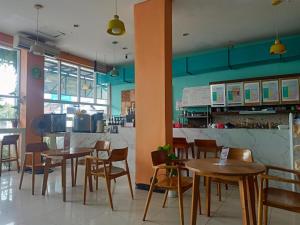 a restaurant with tables and chairs in a room at deKOST Madiun in Madiun