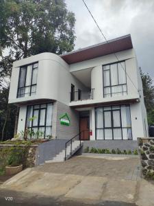 a white house with a staircase in front of it at Naomi Villa Tawangmangu in Tawangmangu