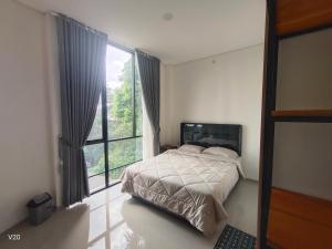 a bedroom with a bed and a large window at Naomi Villa Tawangmangu in Tawangmangu