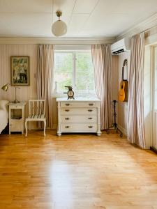 a room with a dresser and a guitar in it at Lake View Holiday Home With Natural Charm in Storfors