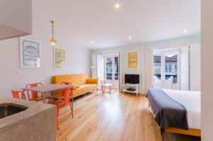 a living room with a bed and a couch and a table at Casas da Baixa - Lighthouse Apartments in Lisbon