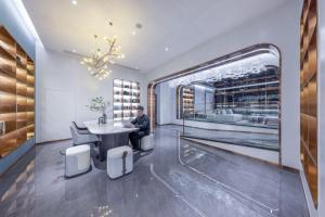 un uomo seduto a un tavolo in una sala di degustazione di vini di Atour Light Hotel Shenzhen Guanlan Sany Cloud a Shenzhen