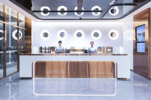 Due donne sedute al bancone in un ristorante di Atour Light Hotel Shenzhen Guanlan Sany Cloud a Shenzhen