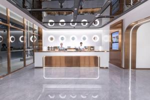 una hall con due persone sedute al bancone di Atour Light Hotel Shenzhen Guanlan Sany Cloud a Shenzhen