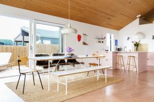 a kitchen and dining room with a white table and chairs at Newly Built Summer House With Sea View in Haderslev