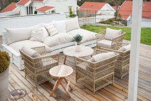 a patio with a couch and chairs and a table at Modern & Charming Summer House Near Risør in Søndeled