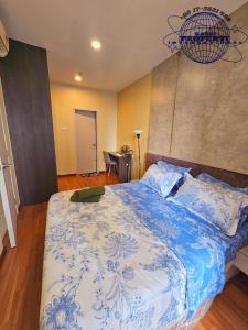 a bedroom with a bed with a blue and white blanket at I-City I-Suite Two Room Free Park BASRI PROPERTI in Shah Alam