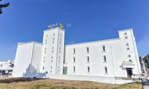 a white building with a sign on top of it at Taean Manripo Feel Hotel in Taean