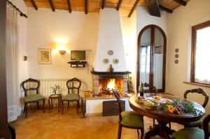 a living room with a fireplace and a table and chairs at Colle sul Lago in Castiglione del Lago