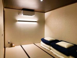 a room with a bed with blue sheets and a ceiling at Misono no Oyado - RO 美園のおやど - ろ #IO2 in Wakayama