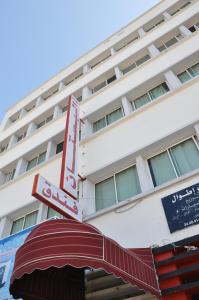 un bâtiment d'hôtel avec un panneau au-dessus d'un auvent dans l'établissement Hotel Boustane, à Casablanca