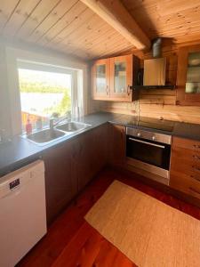 a kitchen with a sink and a stove at Mountain Cabin By Hundsåvatnet With Large Veranda in Fannrem